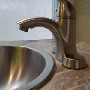 Replaced OEM bathroom sink faucet with a longer reach single lever faucet.