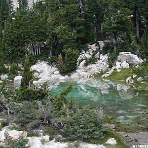 A turquoise green shallow cool water pool above the Bumpass Hell hydrothermal area