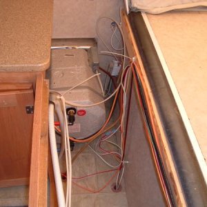 Front Shelf 5: View over water heater with shelf removed.  It is that vanity cover that will have to be loosened (unscrewed and some staples removed) 