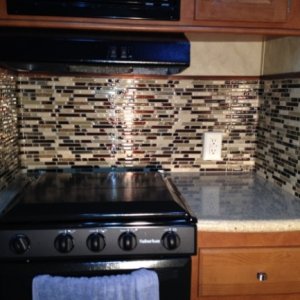 Completed stove top area. Although the surrounding trim pieces add a nice contrasting touch, it is SO hard to get the tiles lined up with each other a