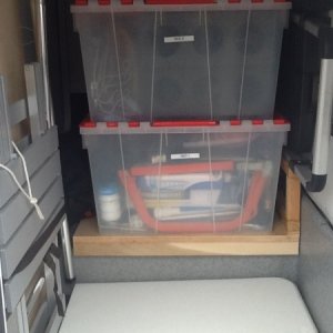 Rear passenger side bay door. Two tote boxes, folding table, ladder, dinette bed brace, outdoor table.