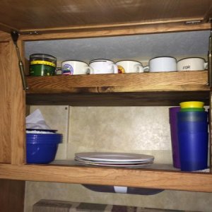 The cabinet above the sink is tapered and a large space leaving dishes stacked and always a mess. With the shelf having a lip allowing the coffee cups