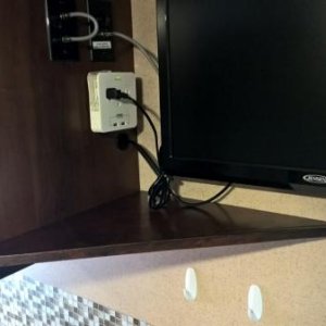 Angle shelf under TV for holding charging phones