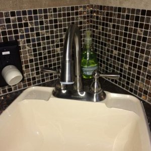 We installed a smart tile backsplash in the bathroom, as well as a Glacier Bay gooseneck faucet so you can actually get your hands under the water! Co