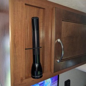 Added bungee cord through wood panel to hold flashlight.  Also visible, the TV.