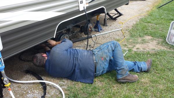 Bruce from Lippert installing new axle on site at the 2014 Crossroads Rally