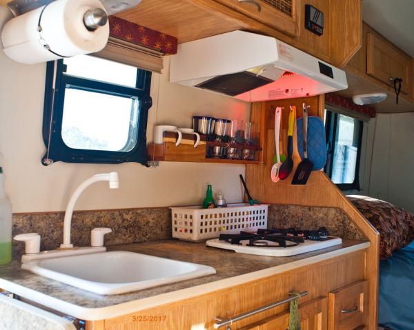 Cup holder/shelf is attached on right to wall, on left to shade screw spool.