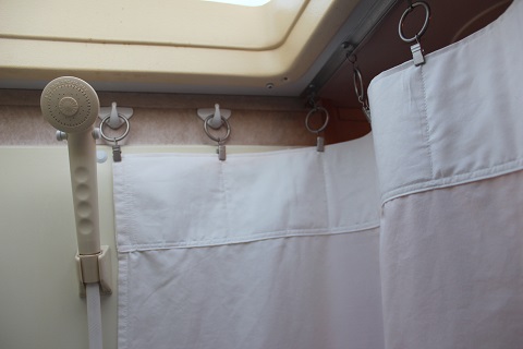 I attached adhesive backed hooks to each end of the shower and used curtain ring clips to attach the curtain to the existing ceiling track and the wal