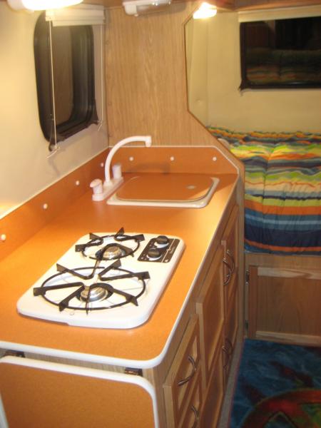 Inside our 2011 Escape19: Atomic Orange Formica, switched stove and sink, eliminated range hood.