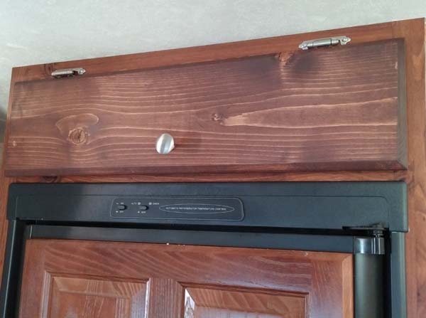 Removed paneling above refrigerator and added door for extra storage.