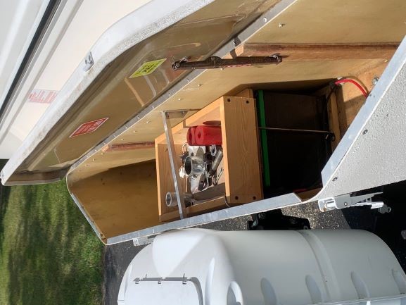 Storage box with tool caddy above batteries