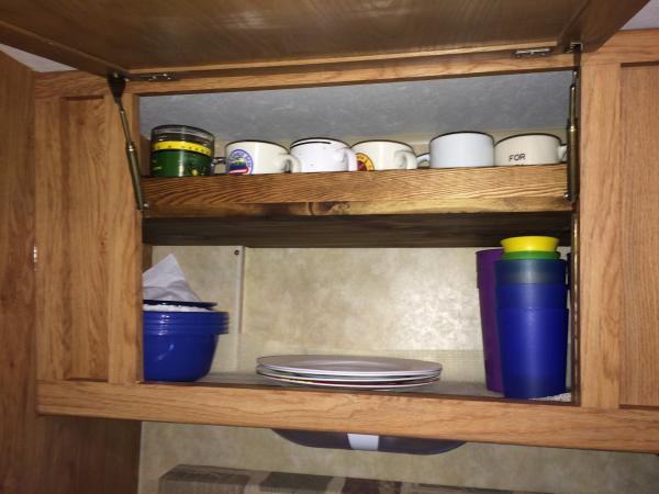 The cabinet above the sink is tapered and a large space leaving dishes stacked and always a mess. With the shelf having a lip allowing the coffee cups